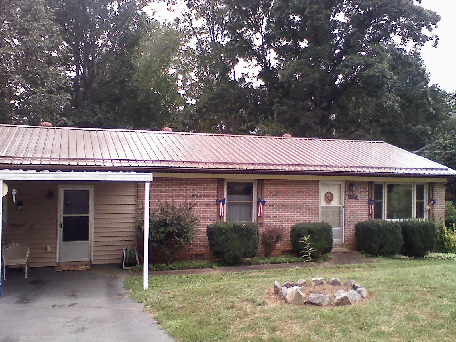 Bronze metal roof and carport on a brick ranch home — Roof Repair work by our crew in Marysville